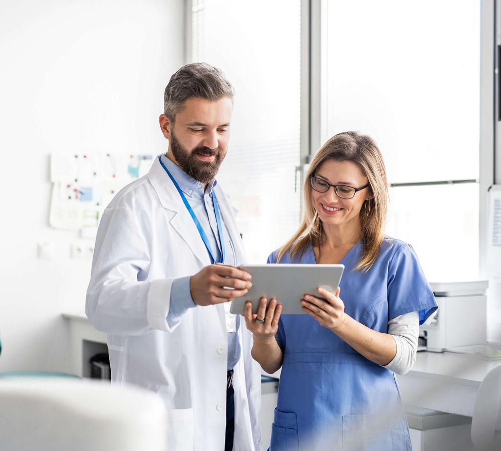 Doctor and nurse reviewing tablet for safety-focused patient care