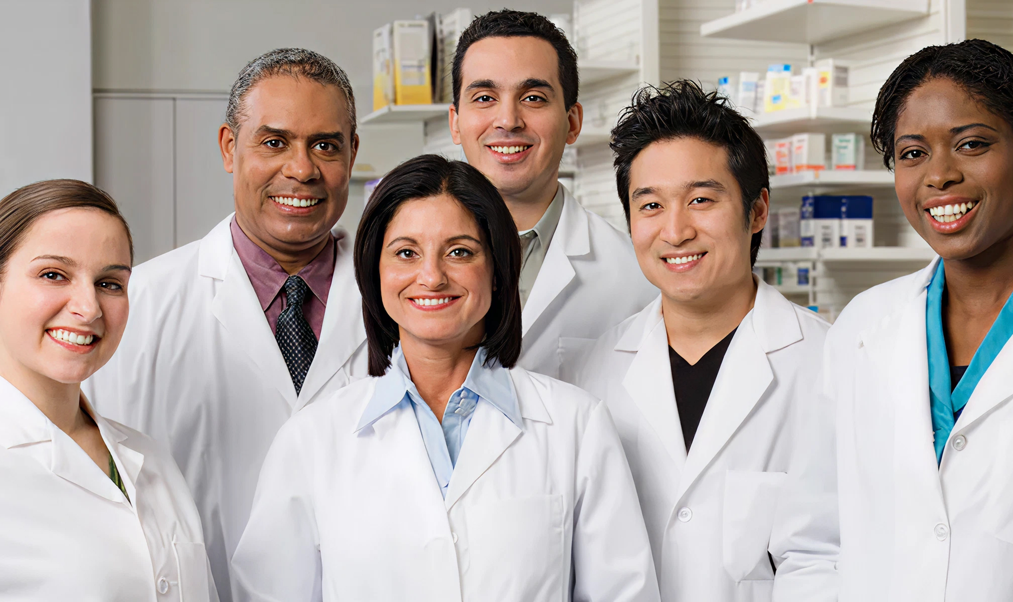 Diverse team of pharmacists standing together in clinical environment