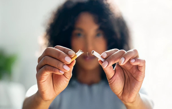A woman breaking a cigarette.